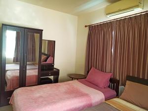 ナイヤンビーチにあるNu Phuket Airport Resident 1のベッド2台と鏡が備わるホテルルームです。