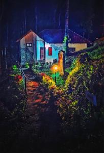 ein Haus mit einem Licht an der Seite in der Nacht in der Unterkunft STAYMAKER Qexperiences Coorg in Madikeri