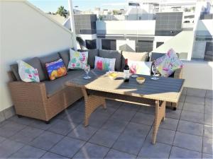 eine Terrasse mit einem Tisch, einem Sofa und Kissen in der Unterkunft Luxury Penthouse Apartment in San Pedro del Pinatar