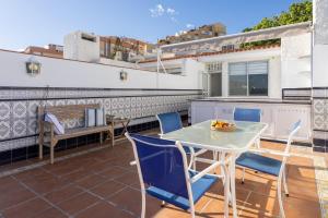 a patio with a table and chairs on a balcony at Home2Book Ocean Breeze Candelaria, Terrace & Pool in Candelaria