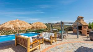patio z basenem z leżakami i parasolami w obiekcie Cortijo Chaparro Algarinejo by Ruralidays w mieście Algarinejo