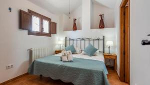 sypialnia z łóżkiem z niebieskimi poduszkami w obiekcie Cortijo Chaparro Algarinejo by Ruralidays w mieście Algarinejo +30 zdjęć