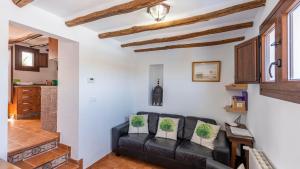 salon z czarną skórzaną kanapą w obiekcie Cortijo Chaparro Algarinejo by Ruralidays w mieście Algarinejo