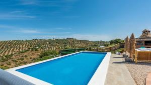 niebieski basen z widokiem na wzgórze w obiekcie Cortijo Chaparro Algarinejo by Ruralidays w mieście Algarinejo