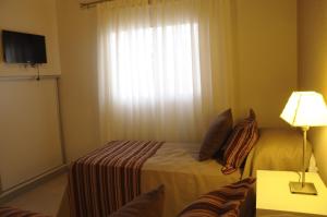 a hotel room with a bed and a window at Lom Suites in Merlo