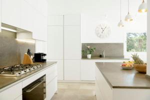 cocina con armarios blancos y fogones en Villa Esquina Luxury 5 Bed 5 Bath Pollensa en Pollença