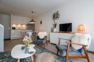 a living room with a table and chairs and a kitchen at Appartement, Kaap 123 - Ameland in Hollum
