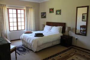 a bedroom with a large bed and a large window at Paul's Place in Dullstroom