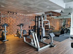 a gym with several tread machines and a brick wall at 4-7 Pax Genting View Resort Kempas Residence -Free Wifi, Netflix And Free Parking in Genting Highlands