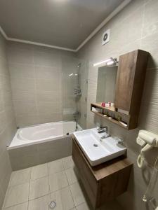 a bathroom with a sink and a bath tub at ORZU HOTEL in Namangan