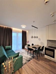 een woonkamer met een groene bank en een tafel bij Aurea apartment in Vilnius