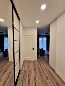 an empty room with a door and a mirror at Aurea apartment in Vilnius