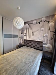 a bedroom with a large bed and chandeliers at Aurea apartment in Vilnius