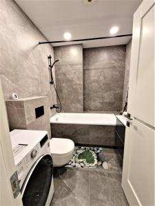 bagno con servizi igienici, lavandino e lavatrice di Aurea apartment a Vilnius