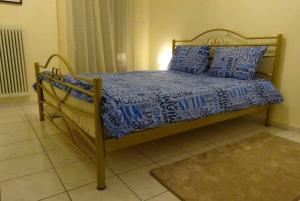 a bed with blue and white sheets and pillows on it at Black & White Apartment ! in Tríkala