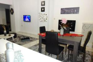 a living room with a dining room table and chairs at Black & White Apartment ! in Tríkala