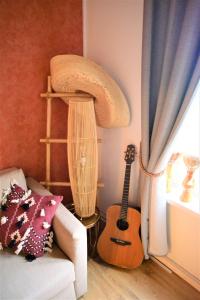 a living room with a guitar and a couch at SLEEP INN - Arizona flat with cityview in Antwerp