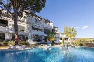 a large swimming pool in front of a building at Luxurious 80m² studio apartment, stunning sea views - Rio Real Golf, Marbella in Marbella