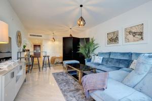 sala de estar con sofá azul y cocina en Luxurious 80m² studio apartment, stunning sea views - Rio Real Golf, Marbella, en Marbella