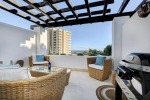 un patio con sillas de mimbre y una mesa en Luxurious 80m² studio apartment, stunning sea views - Rio Real Golf, Marbella, en Marbella