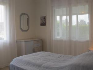 - une chambre avec un lit, un miroir et une fenêtre dans l'établissement Maison Trébeurden, 4 pièces, 6 personnes - FR-1-368-93, à Trébeurden
