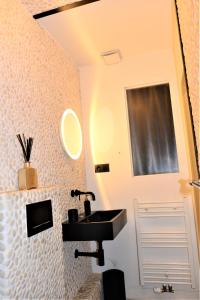 a bathroom with a sink and a mirror at SLEEP INN - Black and White modern flat with cityview in Antwerp