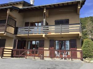 una casa con balcone e sedie di Chalet 6 pers, 2 chambres, parking, Les Angles - FR-1-295-159 a Les Angles