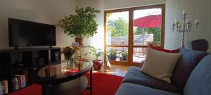 a living room with a blue couch and a glass table at SchlossparkFerienwohnungen Rheinsberg mit Garten in Rheinsberg