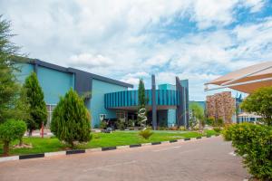 Tlotlo Hotel & Conference Centre في غابورون: مبنى ازرق امامه طريق