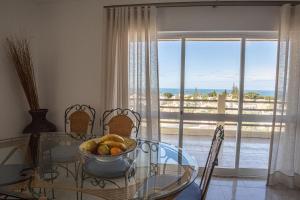 un comedor con una mesa de cristal con un bol de fruta en Palmeira Gale - WIFI - Pool - Lux - BY BEDZY, en Albufeira