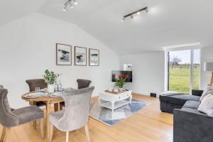 a living room with a table and chairs and a couch at Fen Lane Retreat in Norwich