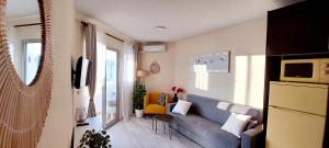 sala de estar con sofá azul y silla amarilla en Hernando Sea Front Optic Fiber Internet Apartment, en Calpe