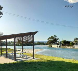 a picnic shelter next to a body of water at Surfmist Barrack Point in Barrack Point