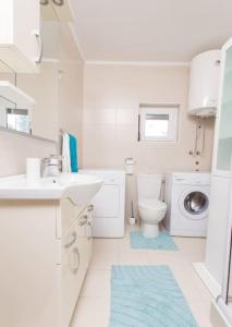 uma casa de banho branca com um lavatório e um WC em Summer retreat em Kotor