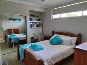 a bedroom with a bed with blue towels on it at Surfmist Barrack Point in Barrack Point