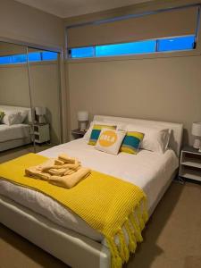 a bedroom with a large bed with a yellow blanket at Surfmist Barrack Point in Barrack Point