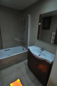 y baño con lavabo, ducha y bañera. en Ithaki Phinikoudes Apartment No. 204, en Lárnaca