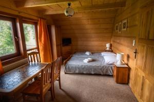 a bedroom with a bed in a log cabin at Szałas pod Szymoszkową in Kościelisko
