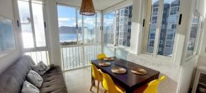 a living room with a couch and a table with yellow chairs at Hernando Sea Front Optic Fiber Internet Apartment in Calpe