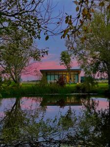 una casa con un estanque delante de ella en Groot Middenhof en Kamperland