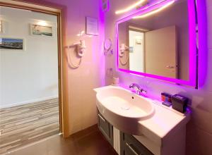 a bathroom with a sink and a mirror with purple lights at Boutique Citadel in Eforie Nord +130 photos