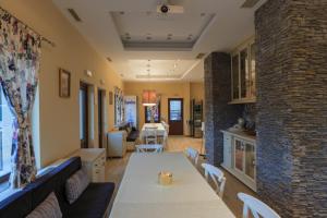 a dining room and living room with a table and chairs at Къща за гости Пилигрим in Skrino
