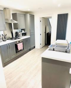 a kitchen with gray cabinets and a white counter top at Northern Lodge in Newport