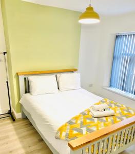 a bedroom with a bed with a yellow and white blanket at Northern Lodge in Newport