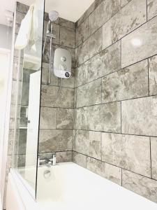 a bathroom with a shower and a bath tub at Northern Lodge in Newport