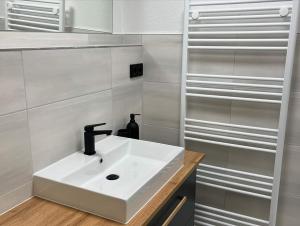 a white sink in a bathroom with white walls at Exklusive Ferienwohnung in Osterburg in Osterburg +3 photos