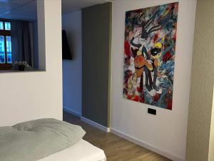 1 dormitorio con una pintura colgada en la pared en Exklusive Ferienwohnung in Osterburg, en Osterburg Siedlung