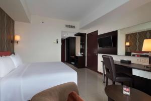 a hotel room with a bed and a desk at Best Western The Lagoon Hotel in Manado