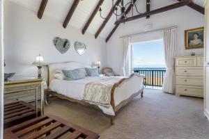 een slaapkamer met een bed en een groot raam bij Strand Beach Lodge in Strand