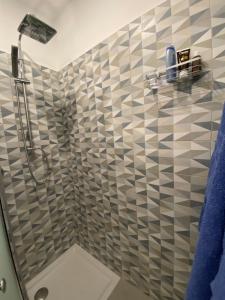 uma casa de banho com um chuveiro e uma parede em azulejo em Casa Quadrifoglio em Taranto